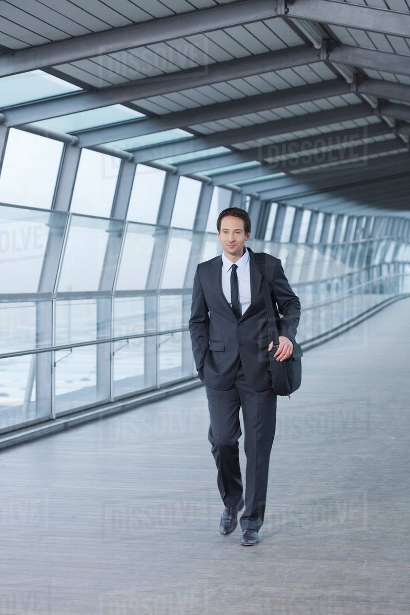 Businessman walking in skywalk Stock Photo Dissolve