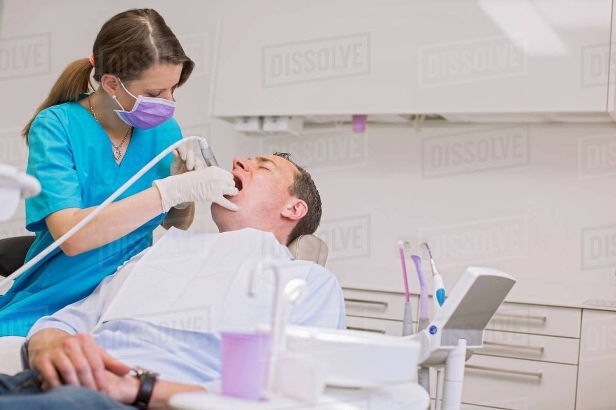 Dentist conducting dental examination on mature man Royalty-free stock photo