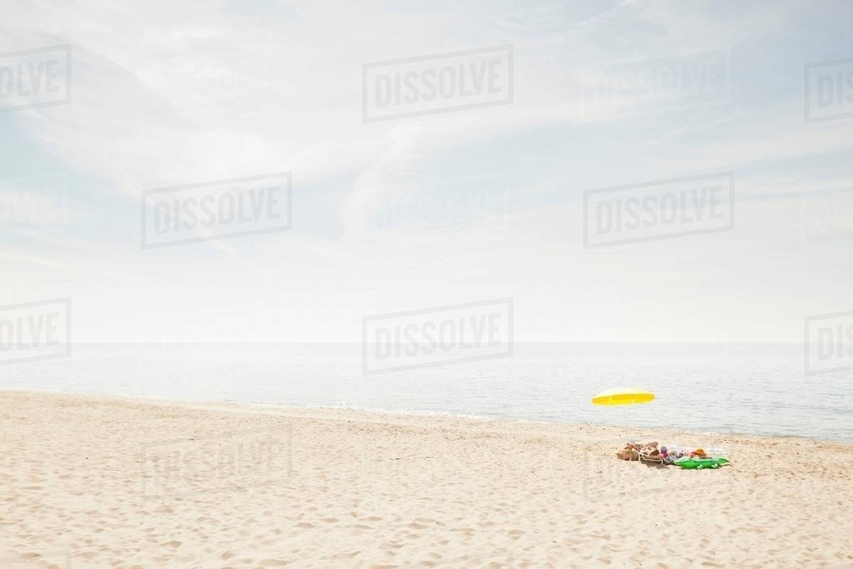 Umbrella and towels on beach Stock Photo Dissolve