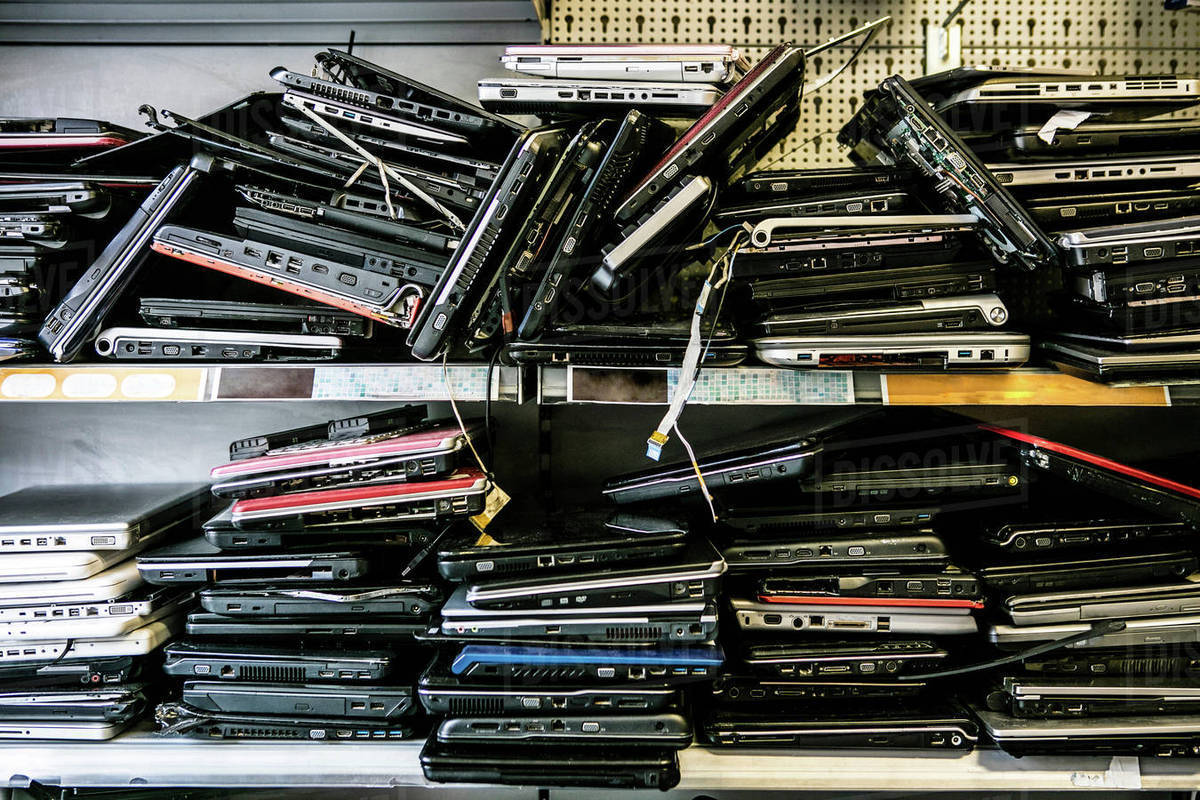 Pile of old, discarded laptops on shelf Stock Photo Dissolve