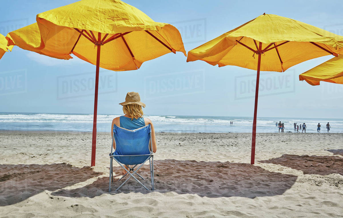 Rear View Of Female Tourist Sitting Under Beach Umbrella Camana Rear View Of Female Tourist Sitting