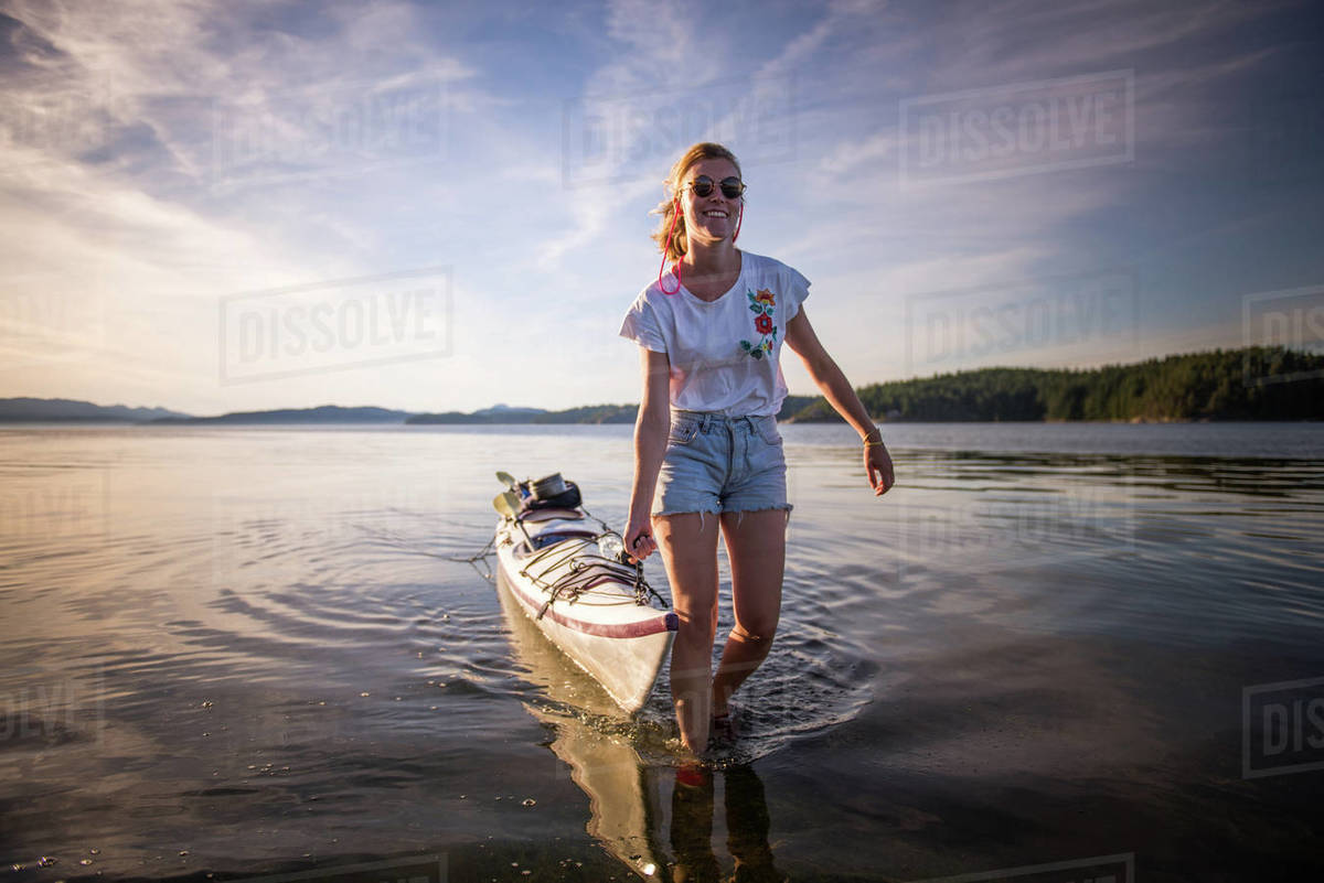 Young female kayaker pulling kayak, Quadra Island, Campbell River