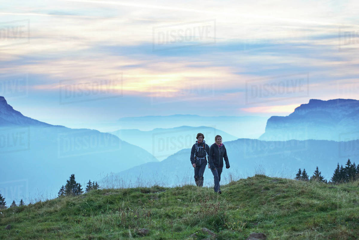 Hikers With Misty Mountains In Background Manigod Rhone Alpes France Stock Photo Dissolve