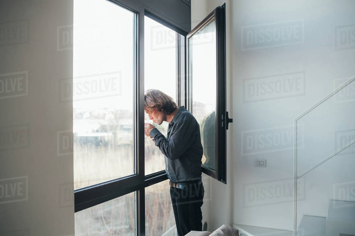 Businessman smoking out of window Stock Photo Dissolve