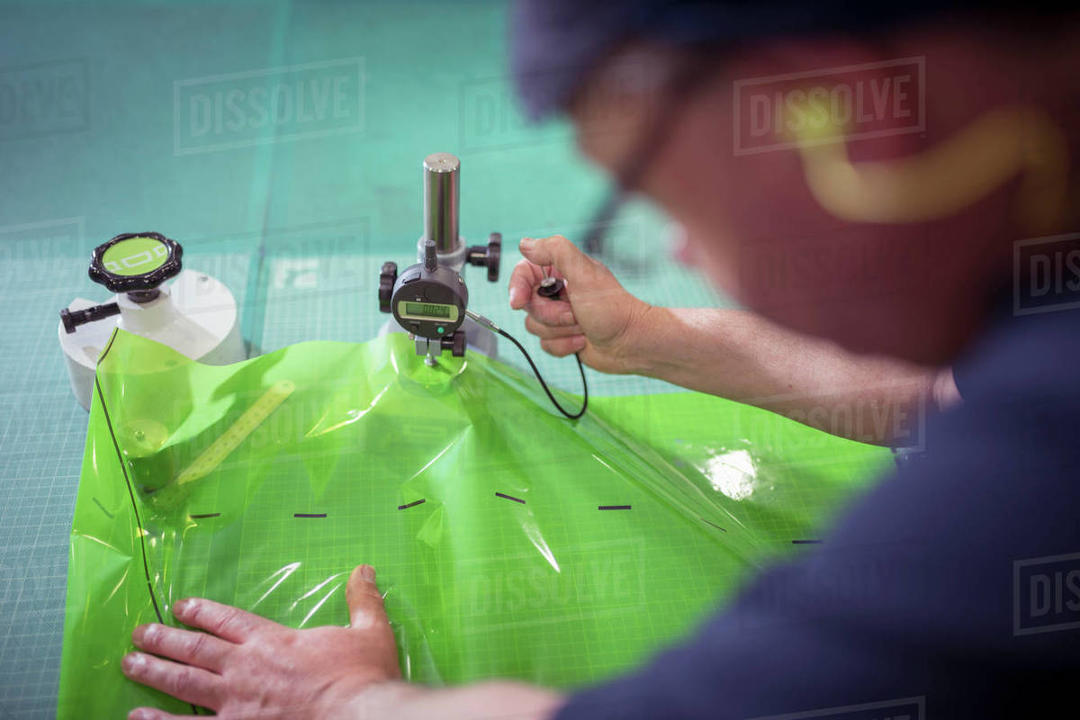 Worker testing plastic packaging material in print factory Stock