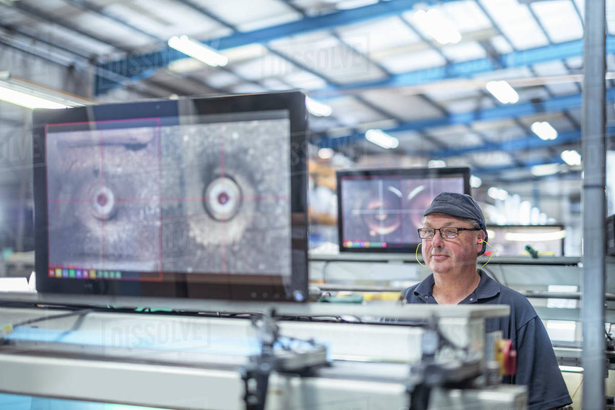 Worker aligning print surface on rollers in print factory Royalty-free stock photo