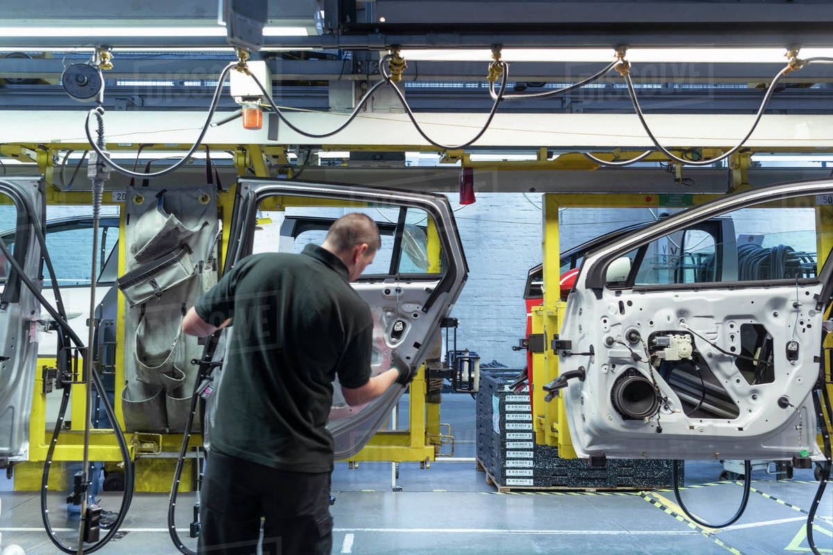 Worker on car door assembly line in car factory Stock Photo Dissolve