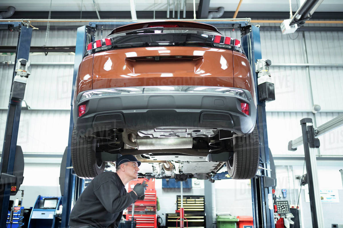 Engineer working under car on lift on car service centre Royalty-free stock photo