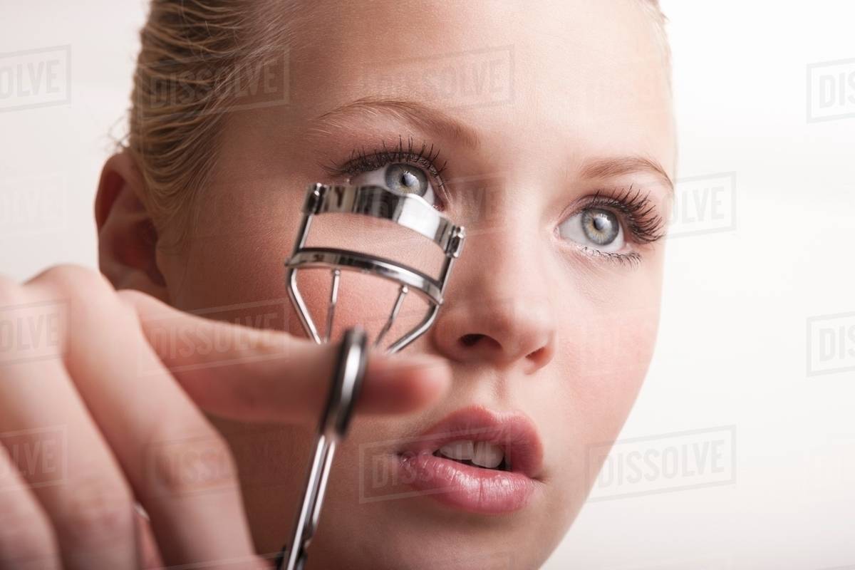 Teenage girl using eyelash curlers Stock Photo Dissolve