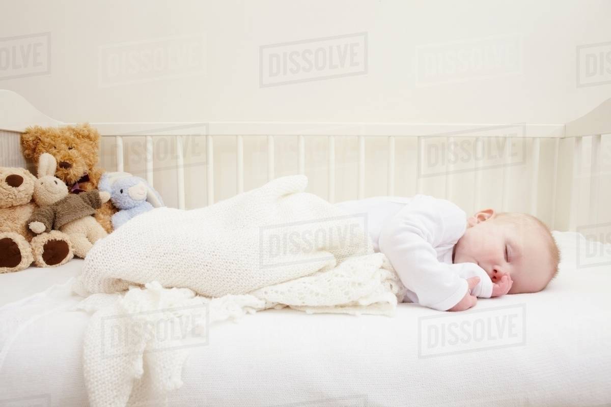 Baby girl sleeping in crib Stock Photo Dissolve