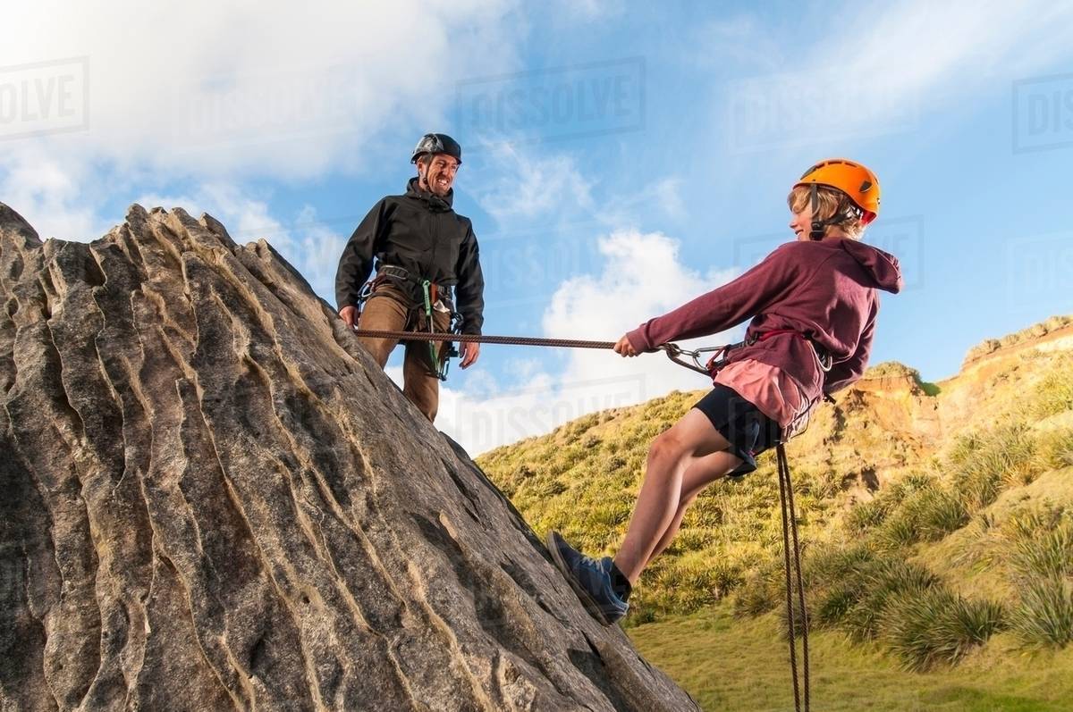 People abseiling in rock climbing lesson Stock Photo Dissolve