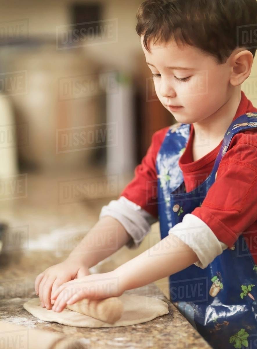 Child kneading dough with rolling pin Stock Photo Dissolve