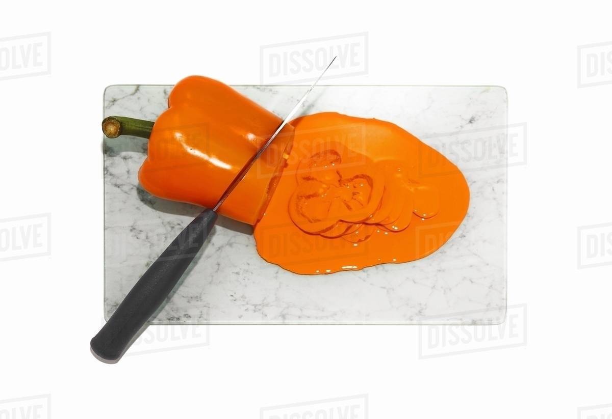 Kitchen knife cutting orange pepper Stock Photo Dissolve