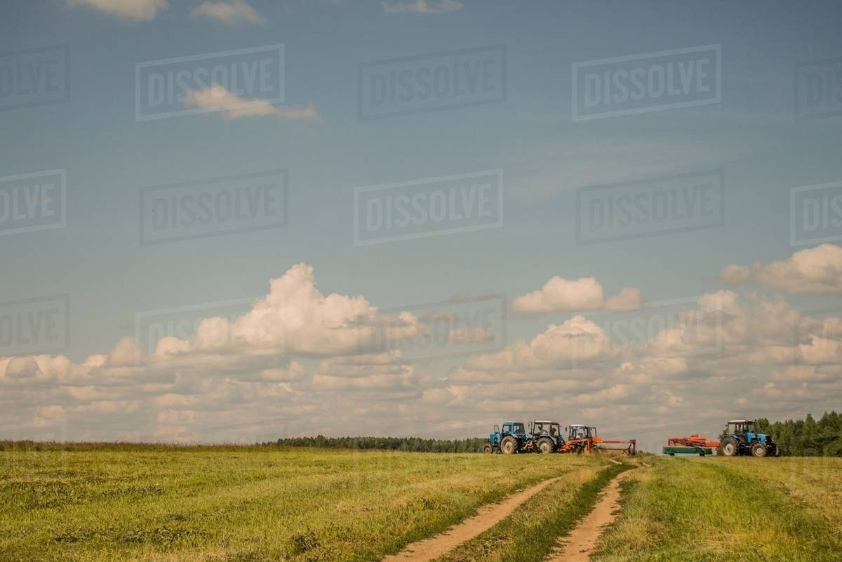 Tractors harvesting field Stock Photo Dissolve