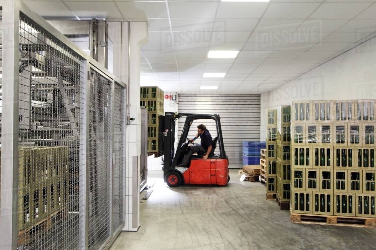 Worker on forklift moving cases of wine Stock Photo Dissolve