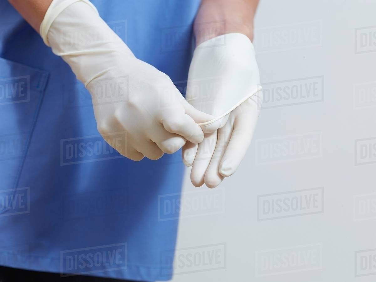 Surgeon putting on latex gloves Stock Photo Dissolve