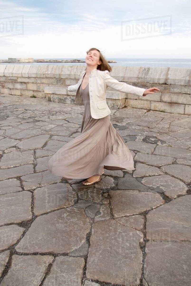 Woman twirling skirt outside - Stock Photo - Dissolve