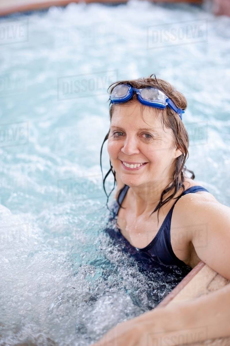 Older woman relaxing in jacuzzi tub Stock Photo Dissolve