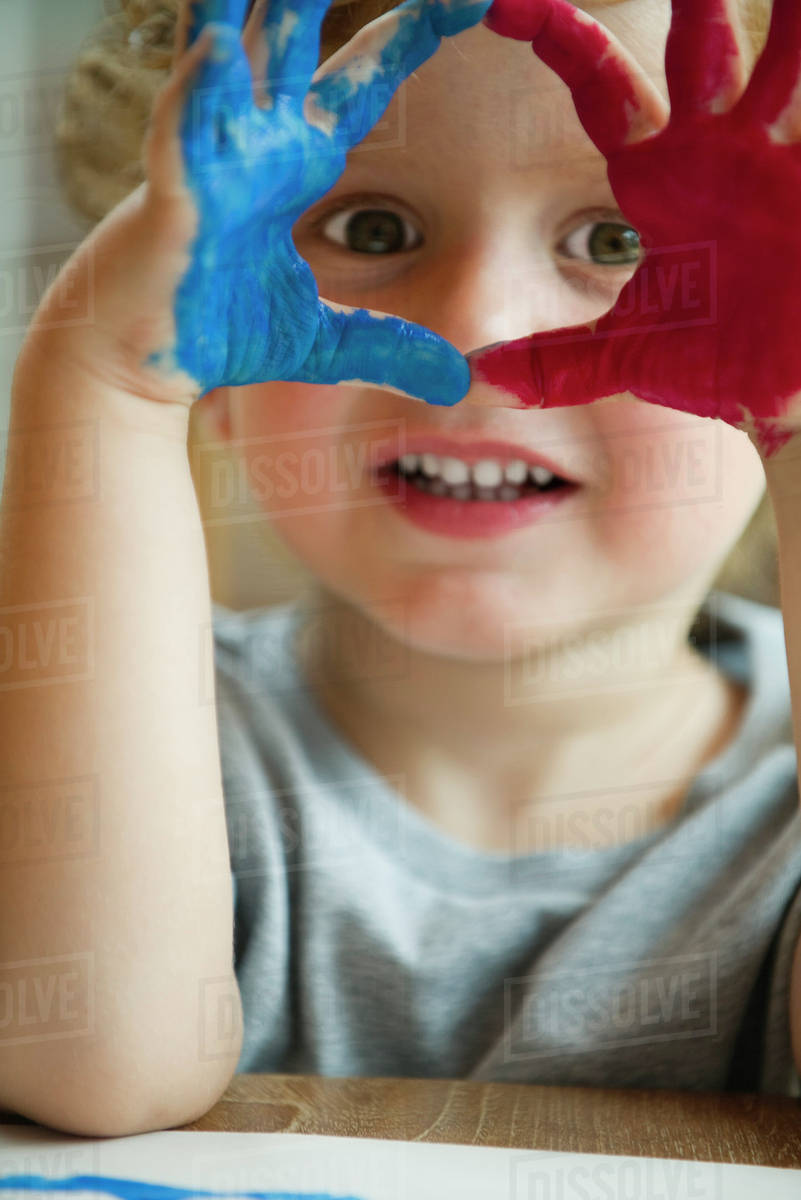 Little boy with hands covered in paint Stock Photo Dissolve