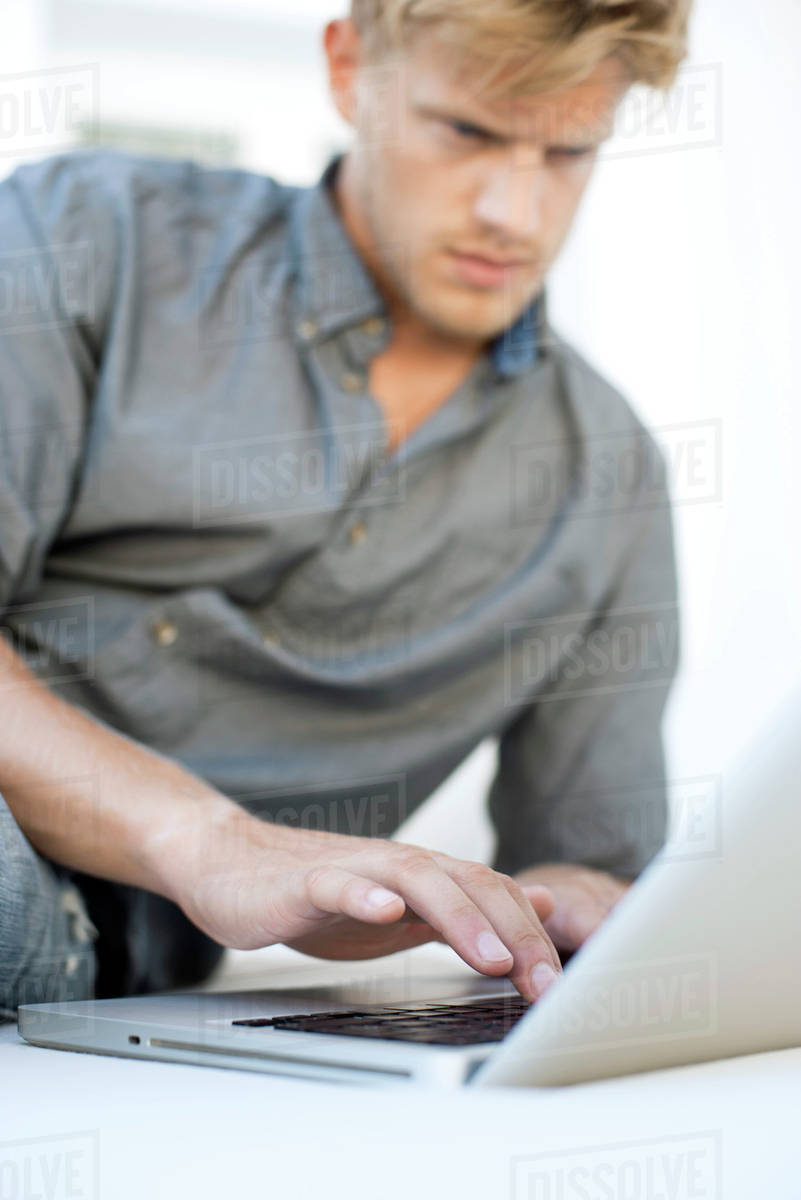 Man using laptop computer - Stock Photo - Dissolve