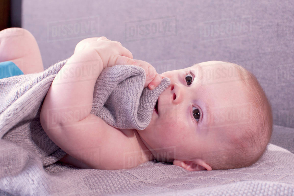 baby-lying-down-holding-blanket-stock-photo-dissolve