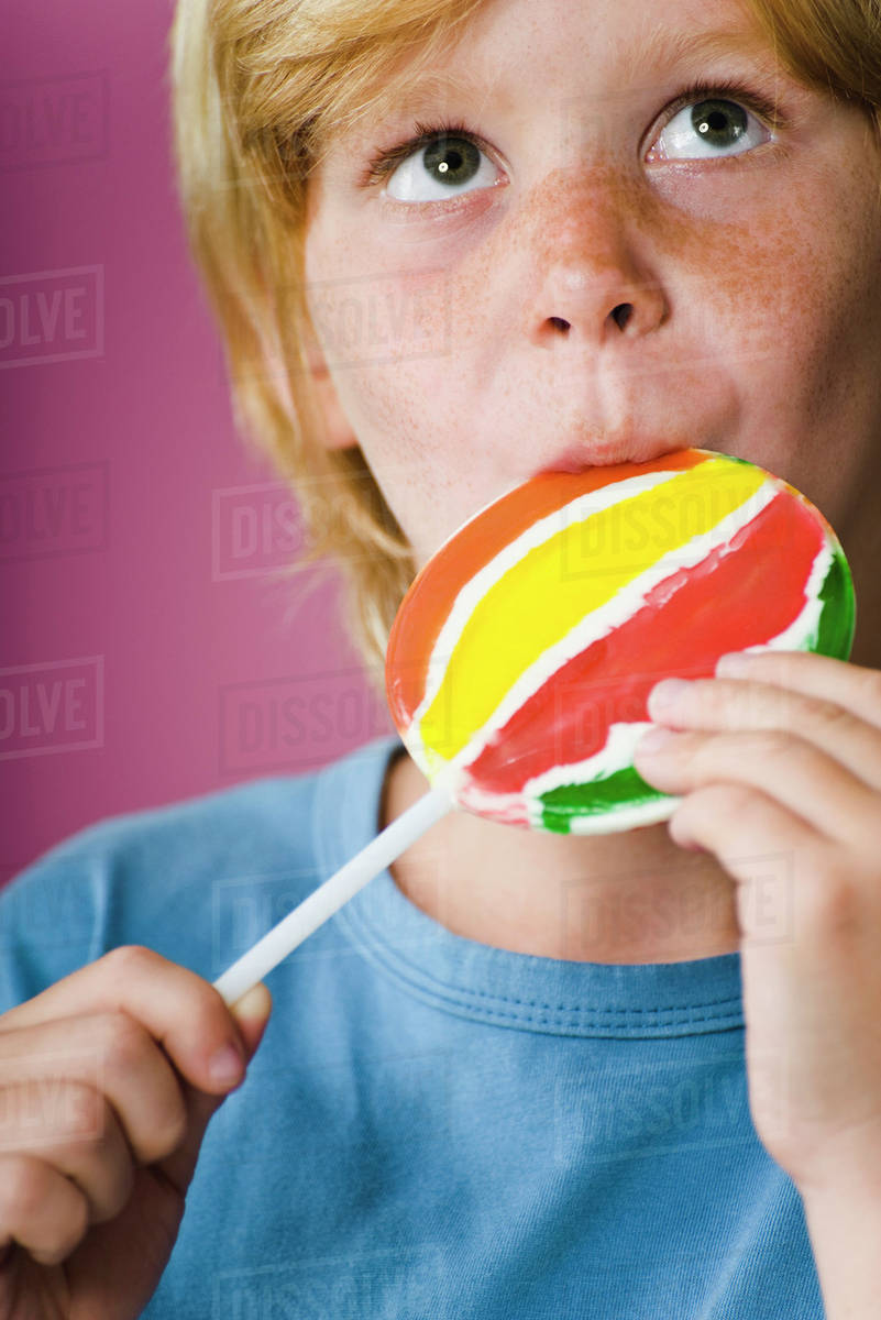 Boy eating lollipop Stock Photo Dissolve