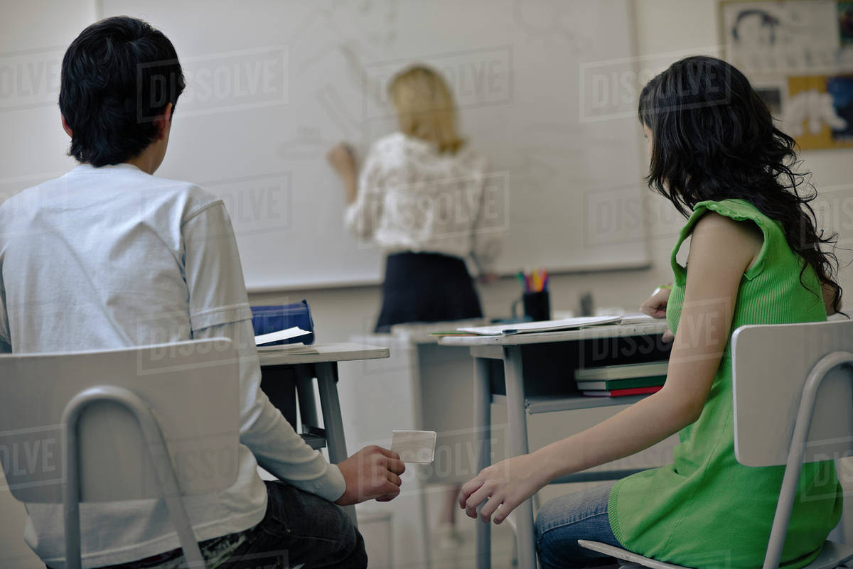 High school students passing notes in class Stock Photo Dissolve