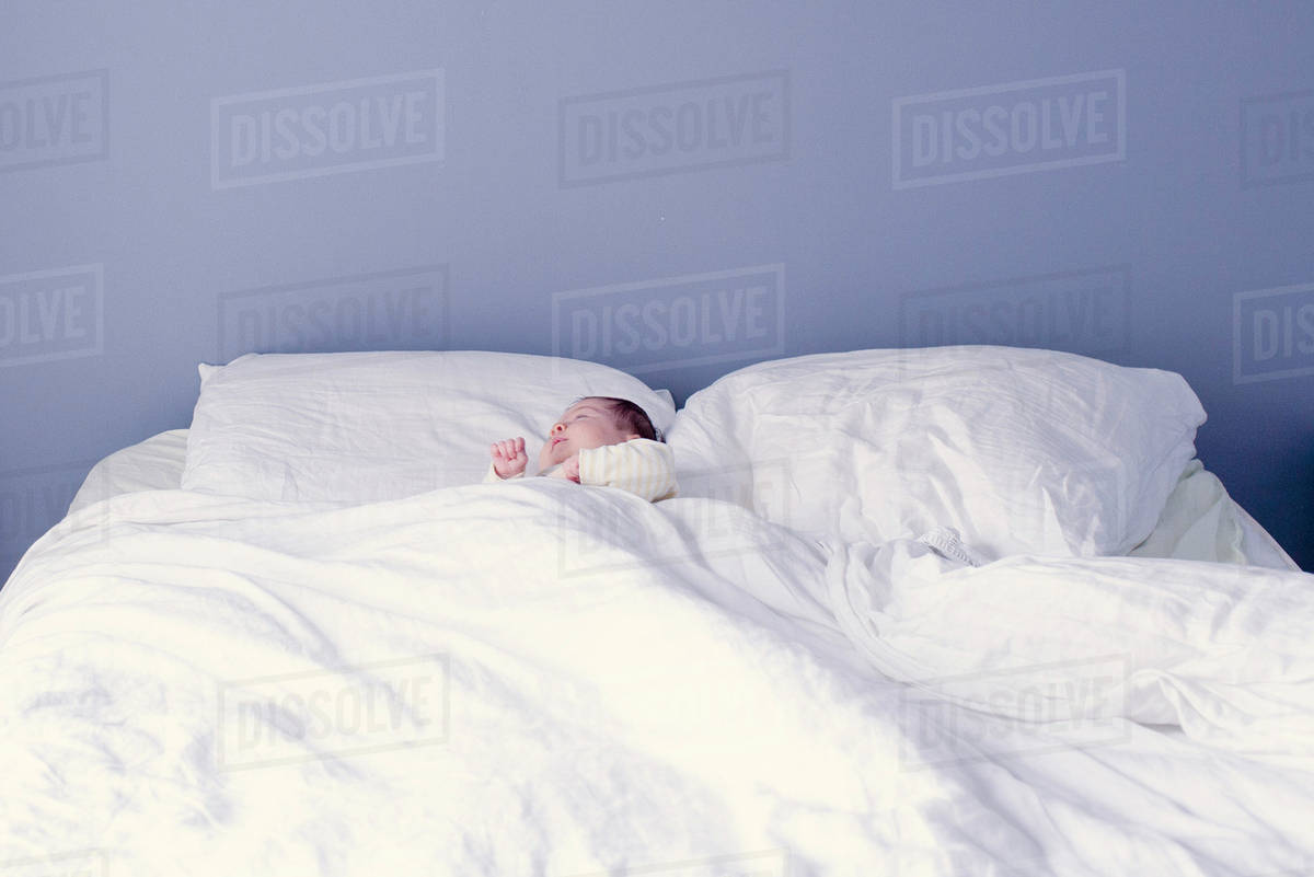 New born baby sleeping in bed Stock Photo Dissolve