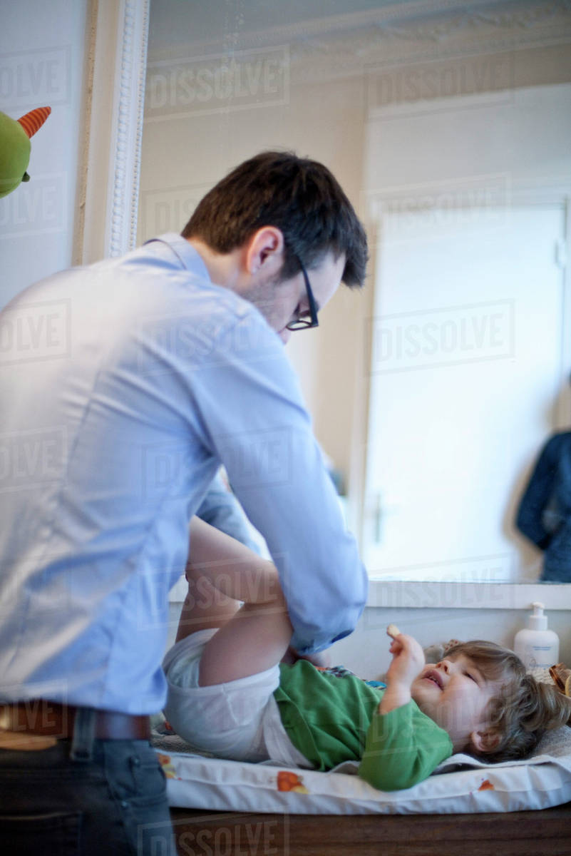 Father changing son's diaper Stock Photo Dissolve