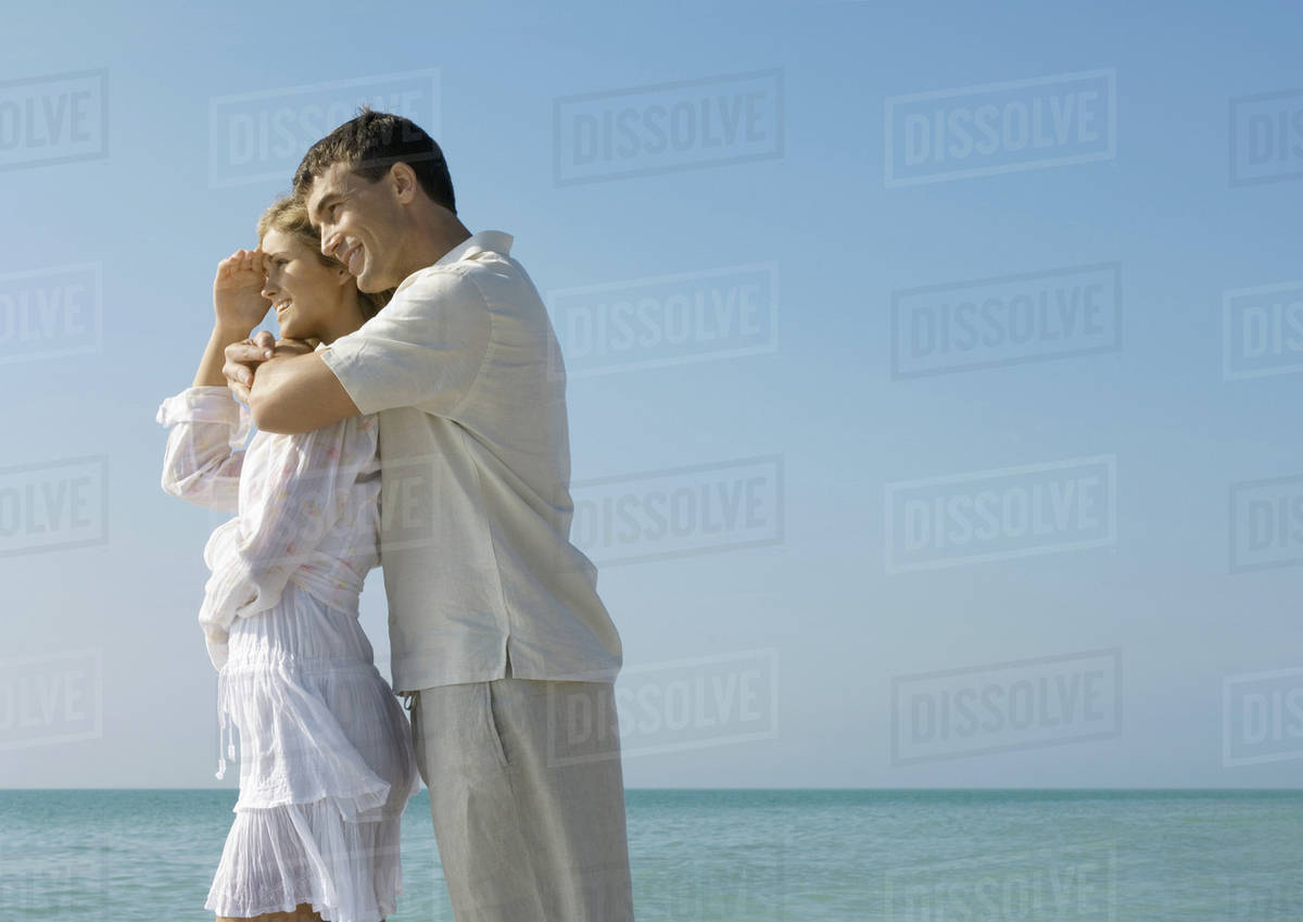 Man hugging woman on beach - Royalty-free Stock Photo | Dissolve
