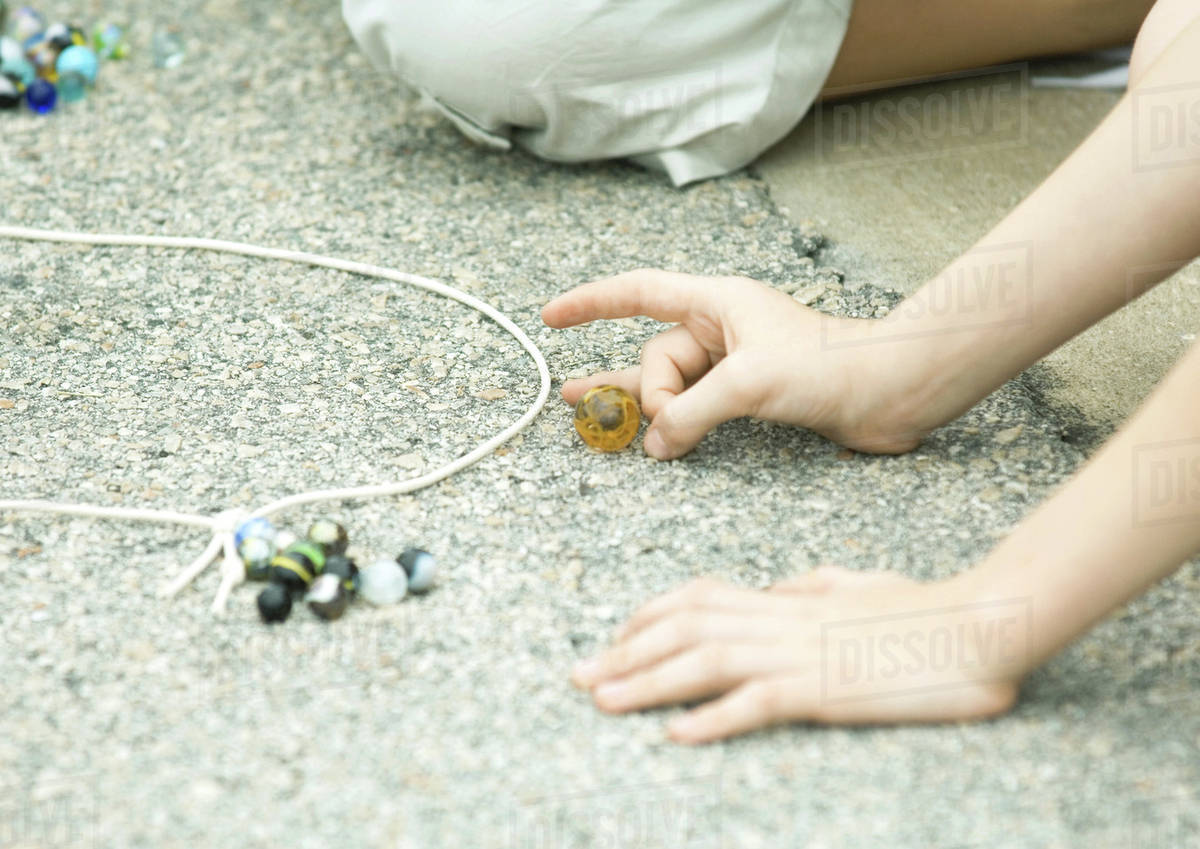 Children playing marbles on asphalt Stock Photo Dissolve