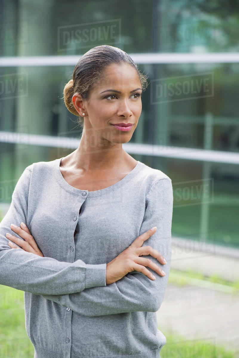 Woman with arms folded across chest, determined expression on face