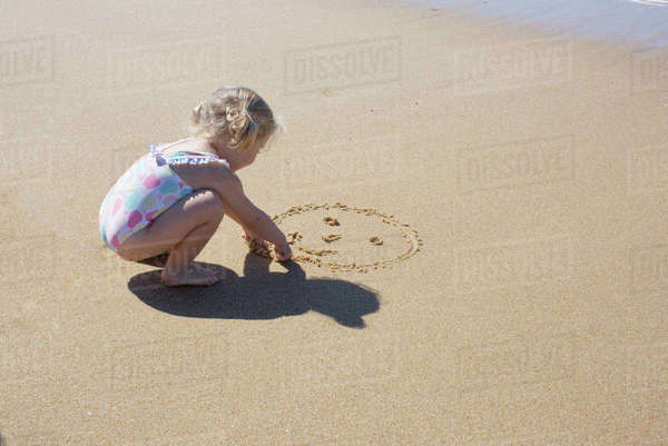 Girl making angel in sand on beach, high angle view - Stock Photo ...