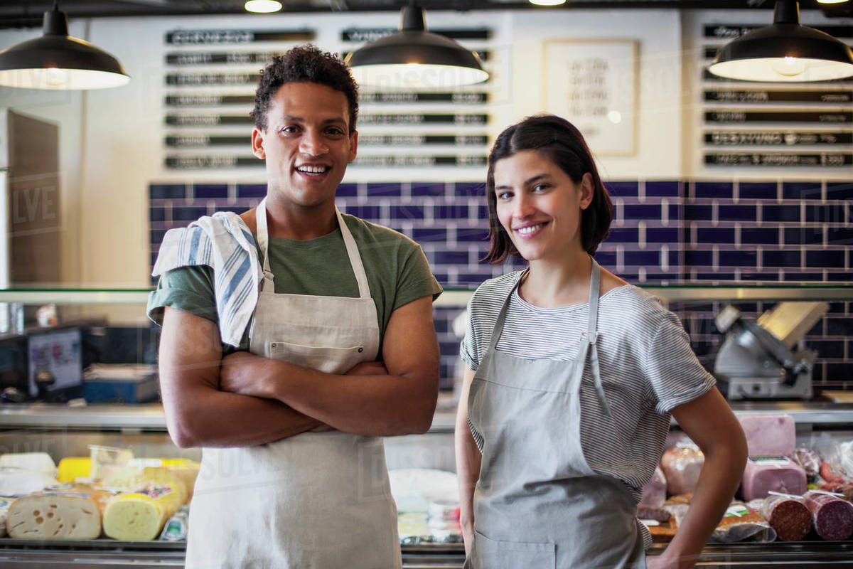 Grocery store owners looking at the camera Stock Photo Dissolve