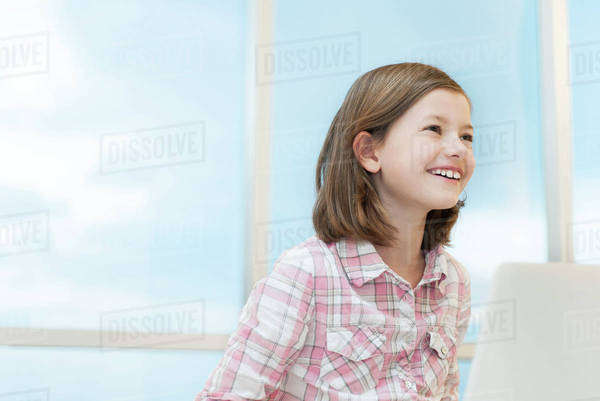 Girl using laptop computer, smiling - Royalty-free Stock Photo | Dissolve