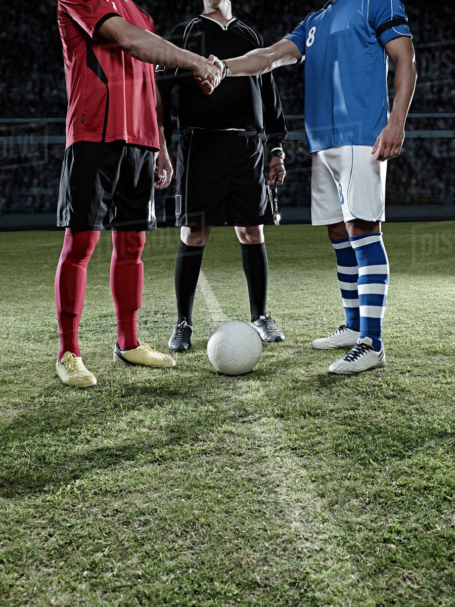 Soccer players shaking hands on field Stock Photo Dissolve