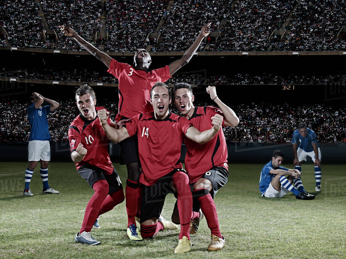 Soccer players cheering on field Stock Photo Dissolve