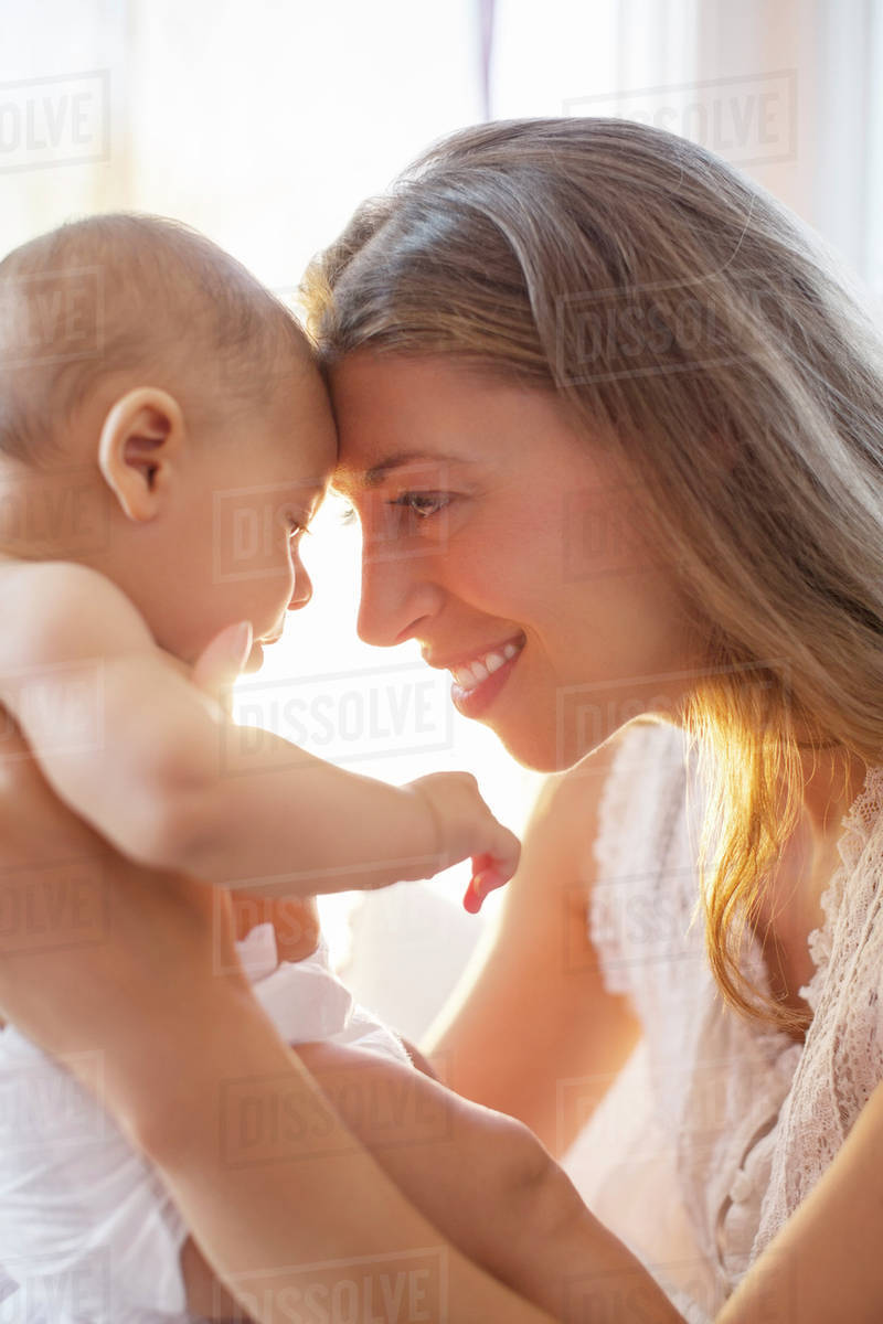 Mother touching foreheads with baby boy Stock Photo Dissolve