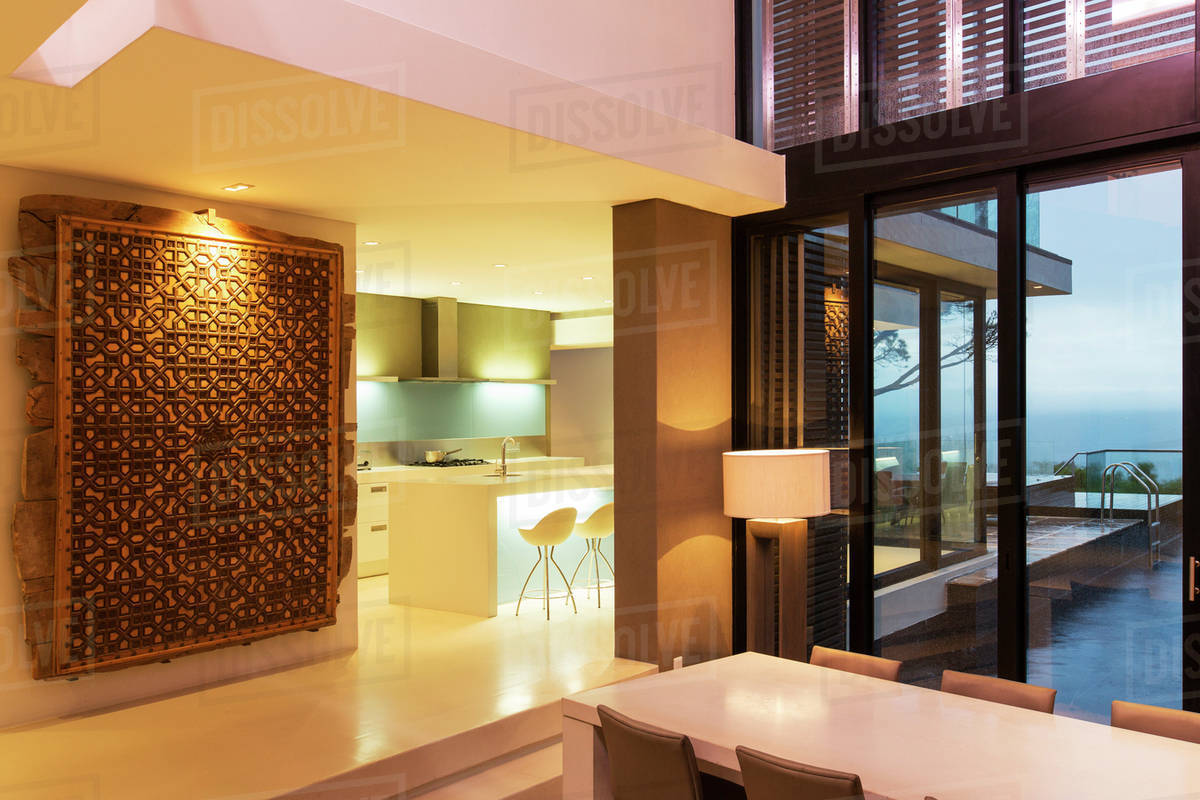 View Of Modern Dining Room And Kitchen With Abstract Painting View Of Modern Dining Room And Kitchen With Abstract Painting Hanging On Wall