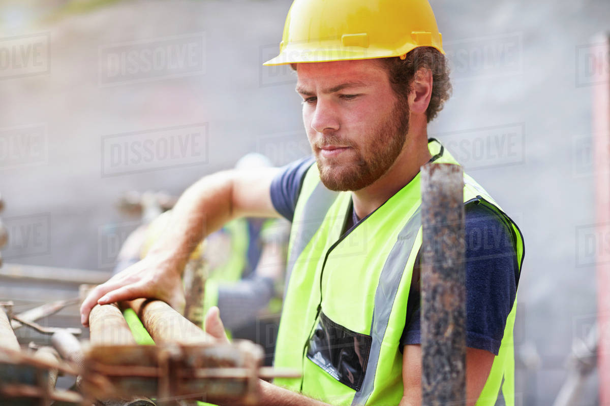 Construction worker lifting rebar Stock Photo Dissolve