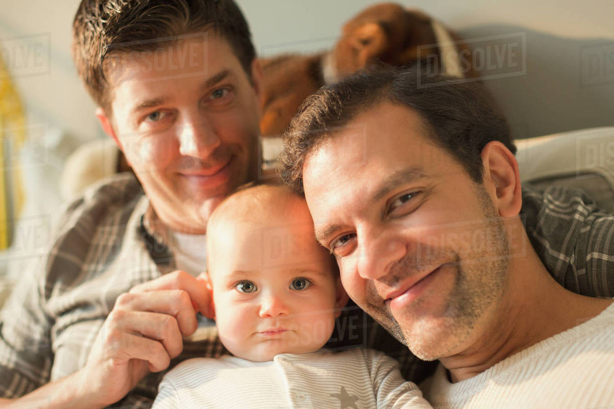 Portrait smiling male gay parents and cute baby son Royalty-free stock photo