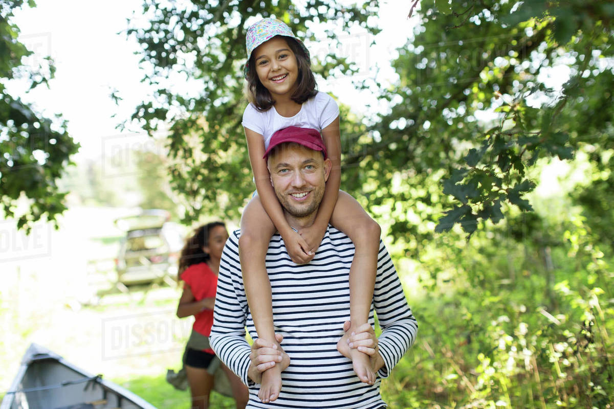 Portrait father carrying daughter on shoulders in woods Royalty-free stock photo