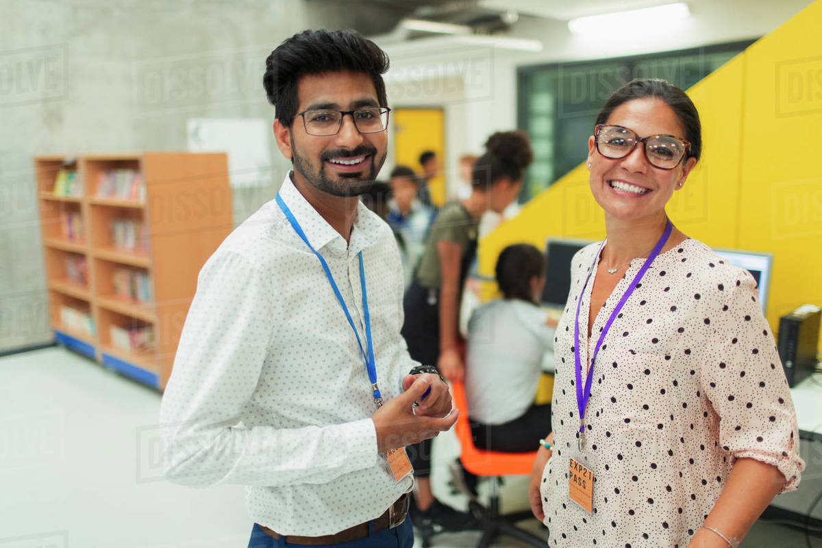 Portrait smiling, confident junior high teachers in library Royalty-free stock photo