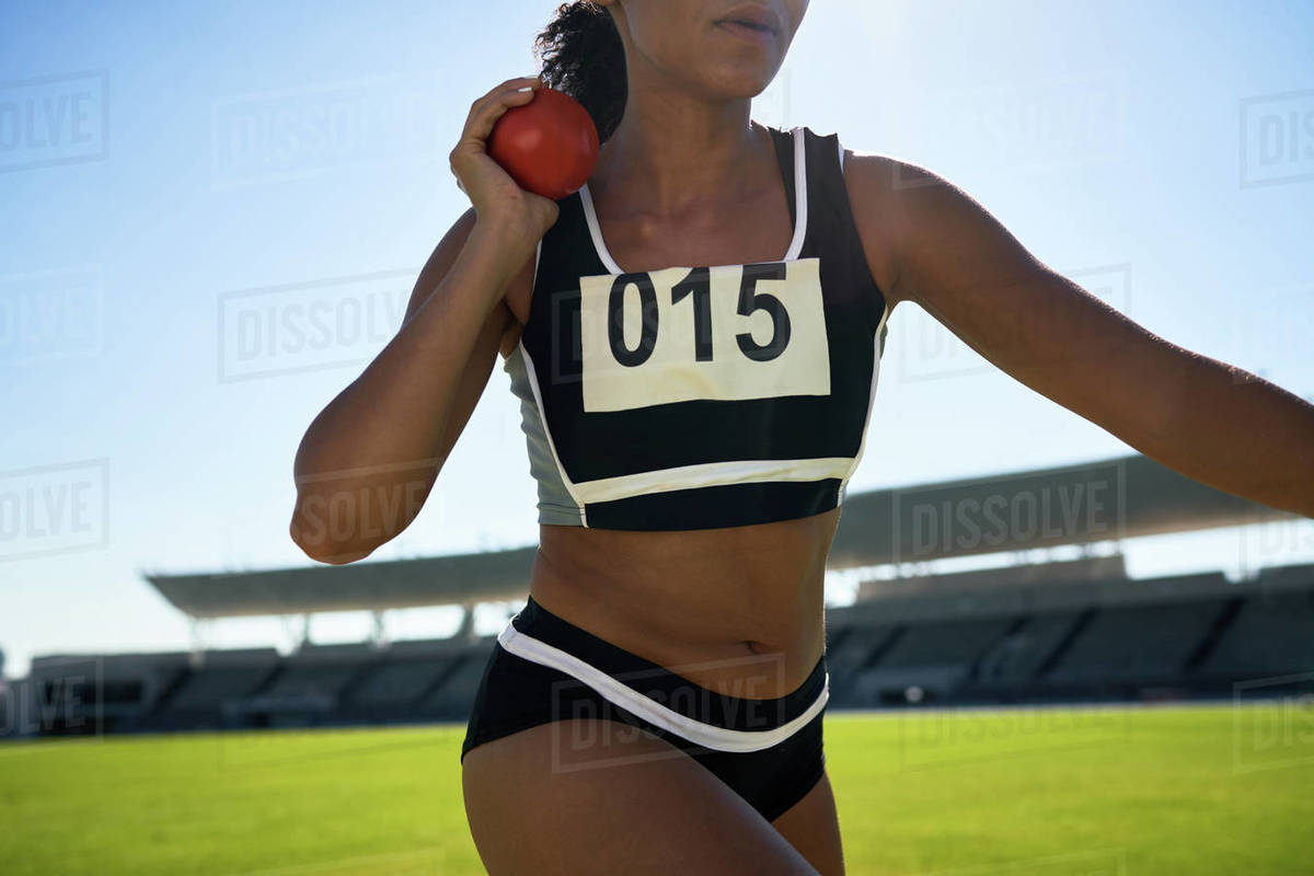 Close up female track and field athlete throwing shot put Stock Photo