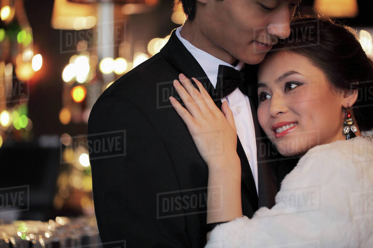 Dressed up couple hugging each other at night Stock Photo Dissolve