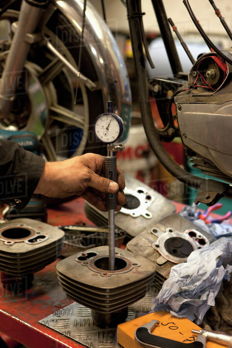 Mechanic checking cylinder bores with a dial bore gauge, Stock Photo