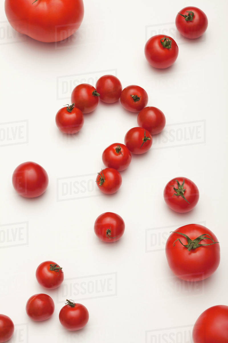 Small tomatoes arranged into a question mark, surrounded by different