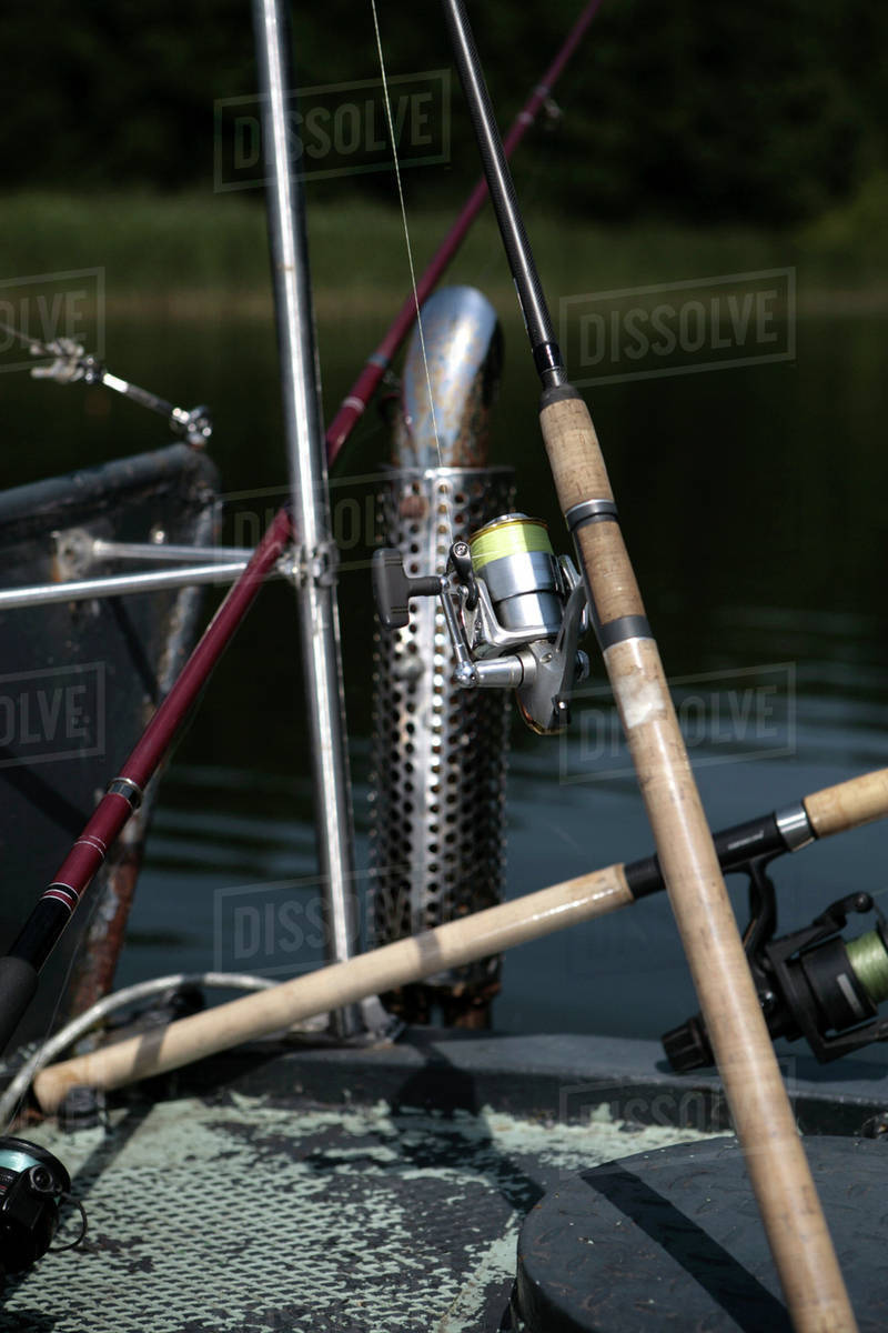 An arrangement of various fishing rods on a lake jetty Stock Photo