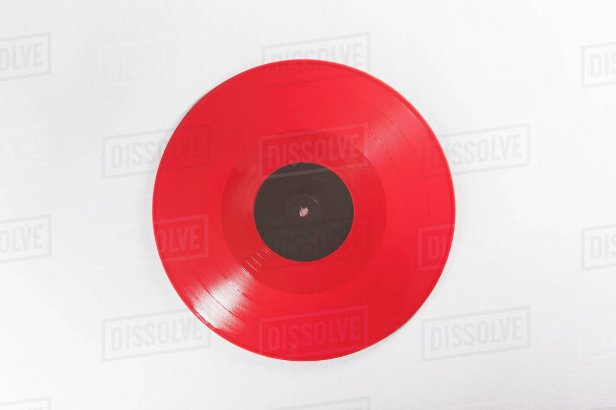 Close-up of red record over white background - Stock Photo - Dissolve