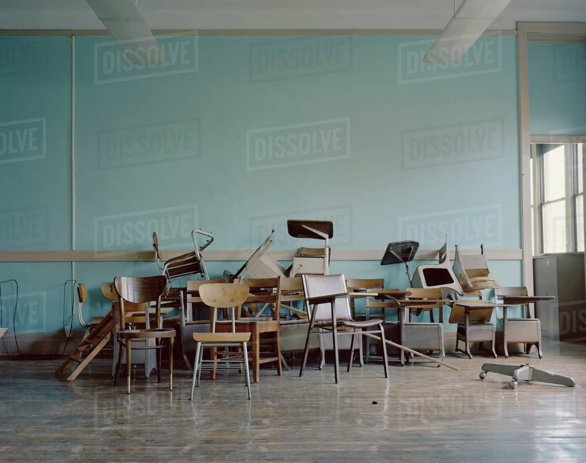 Old, broken chairs in an abandoned school Stock Photo Dissolve